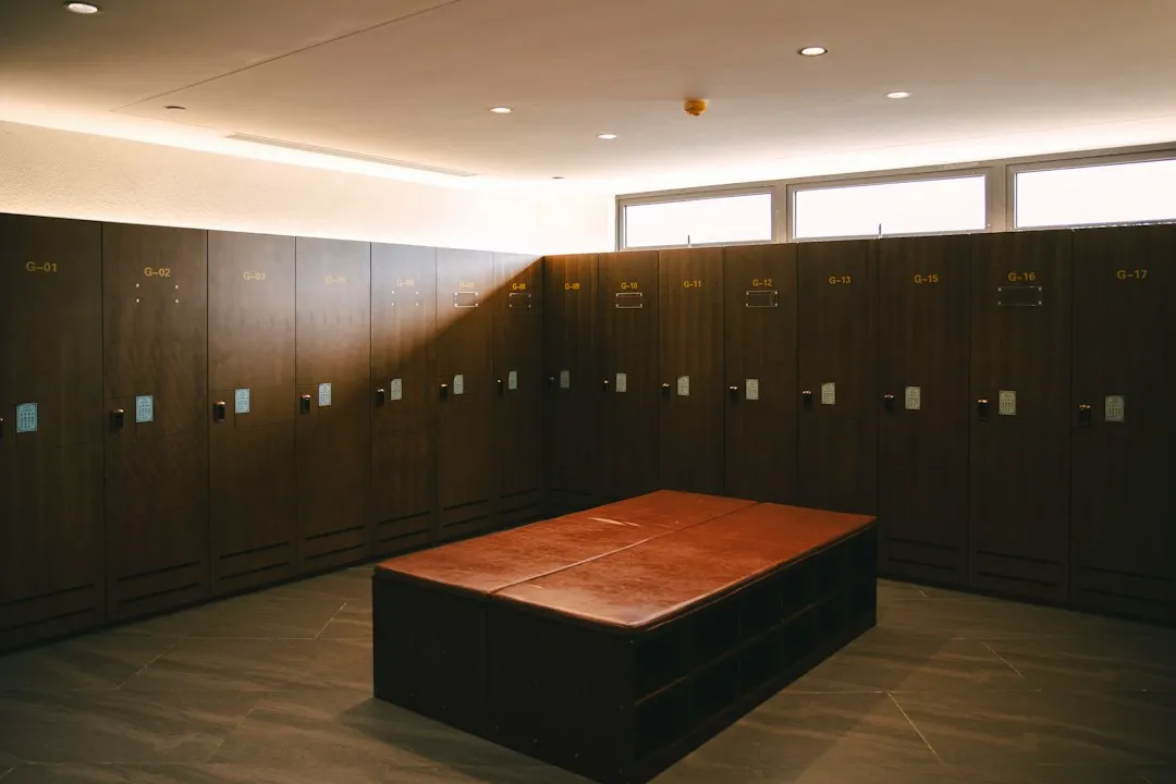 Illustrative empty changing room with wooden lockers and a central bench