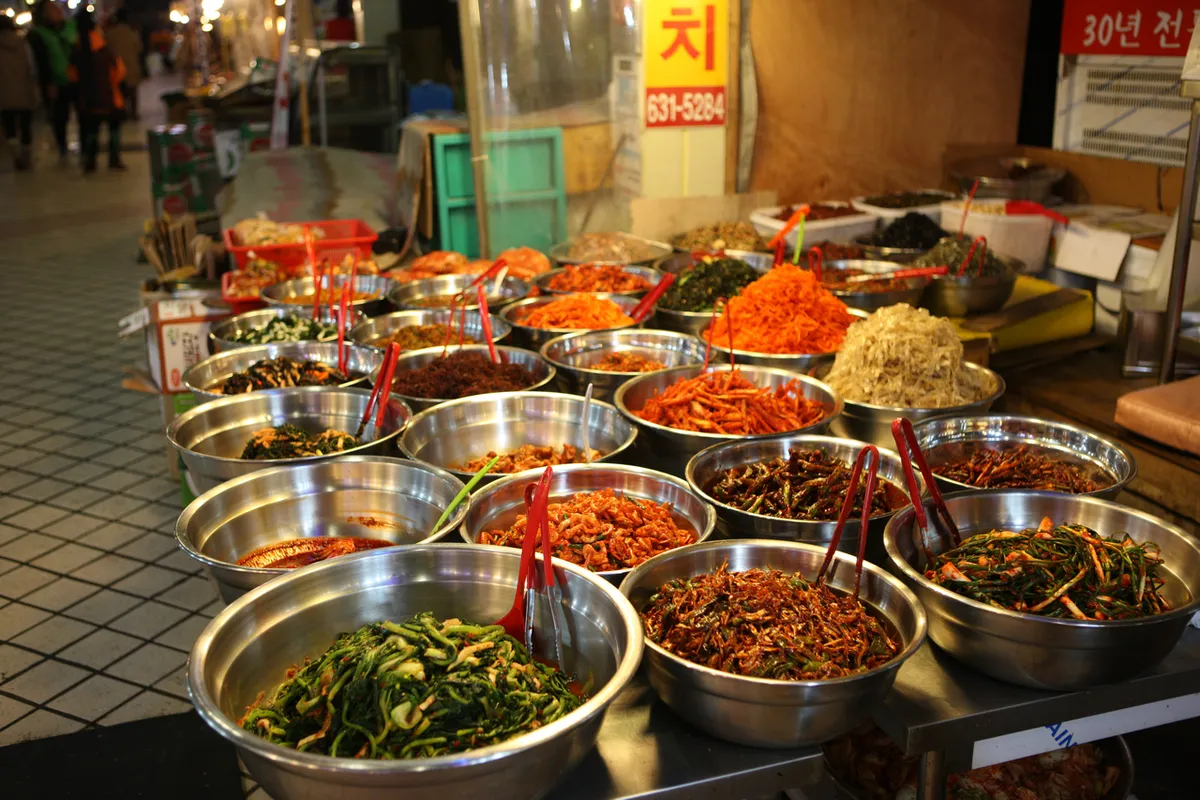 Korean market counter with banchan side dishes and seafood items