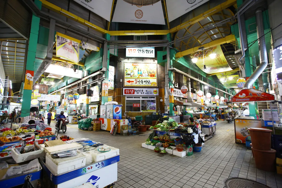 Traditional market stalls with packaged goods and food displays for Korea shopping list