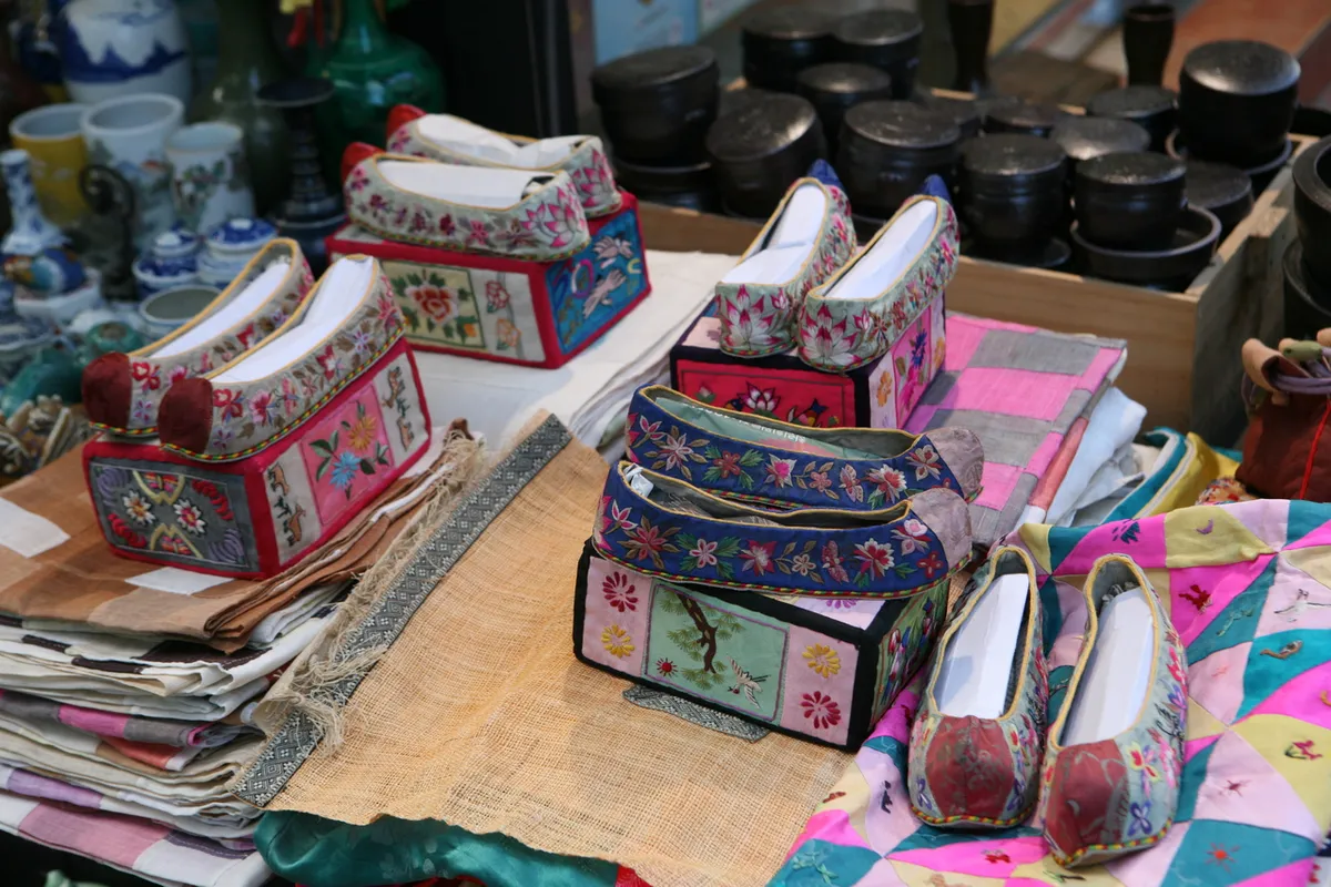 Traditional shoes and craft souvenirs displayed at an Insadong shop for Korea shopping gifts