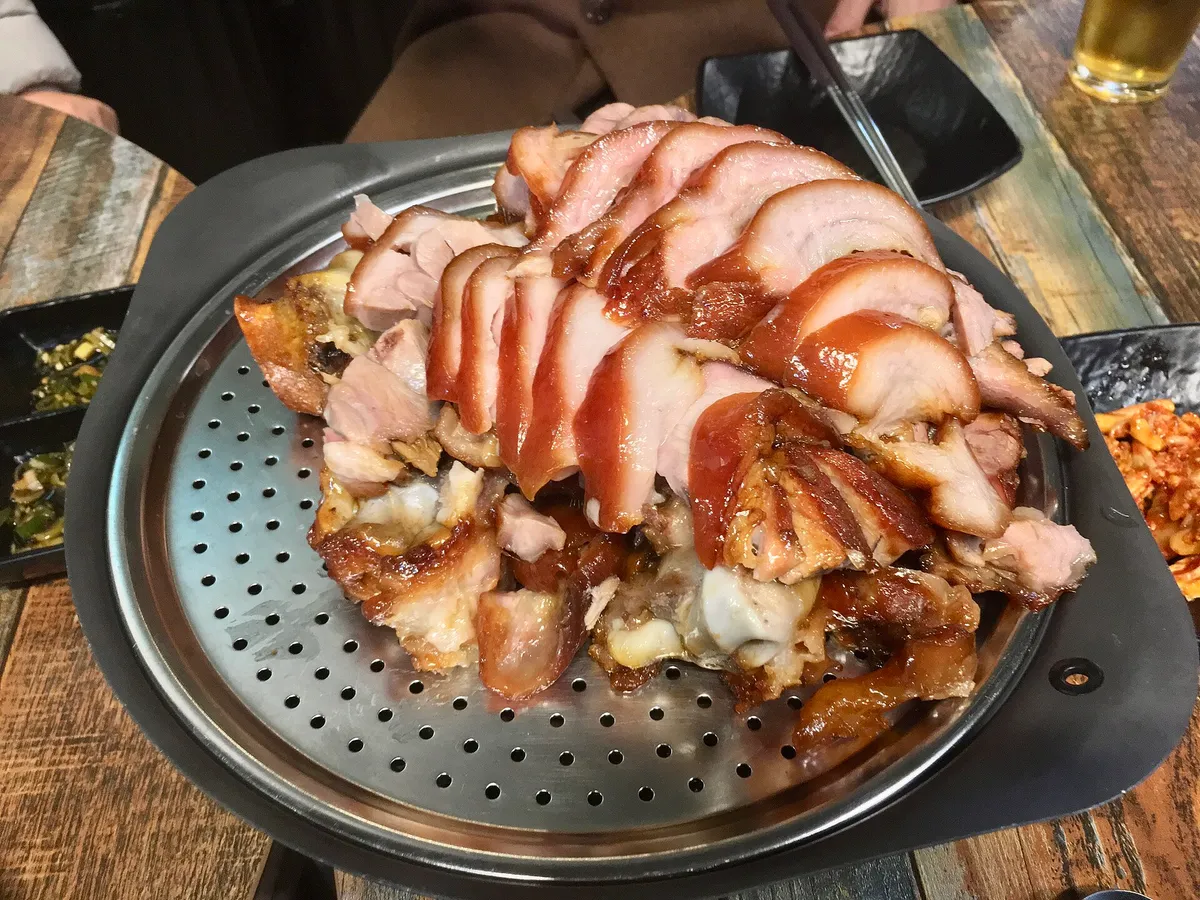 Jokbal sliced pig feet served on a metal plate for Korean pork guide