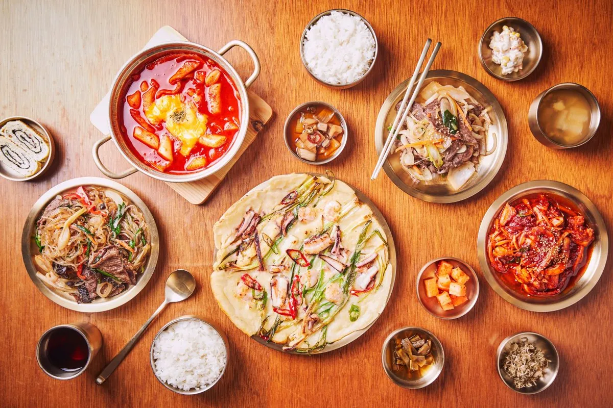 Korean meal table with bulgogi, pancakes, rice, kimchi, and side dishes