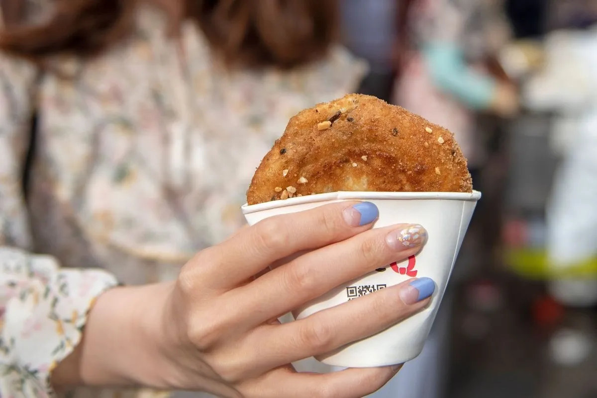 Hotteok held in a paper cup at Bupyeong Kkangtong Market in Busan