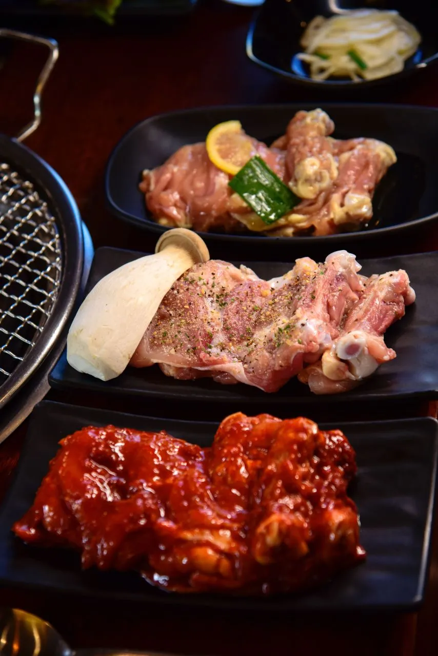 Seasoned chicken portions prepared beside a charcoal grill for sutbul Dakgalbi