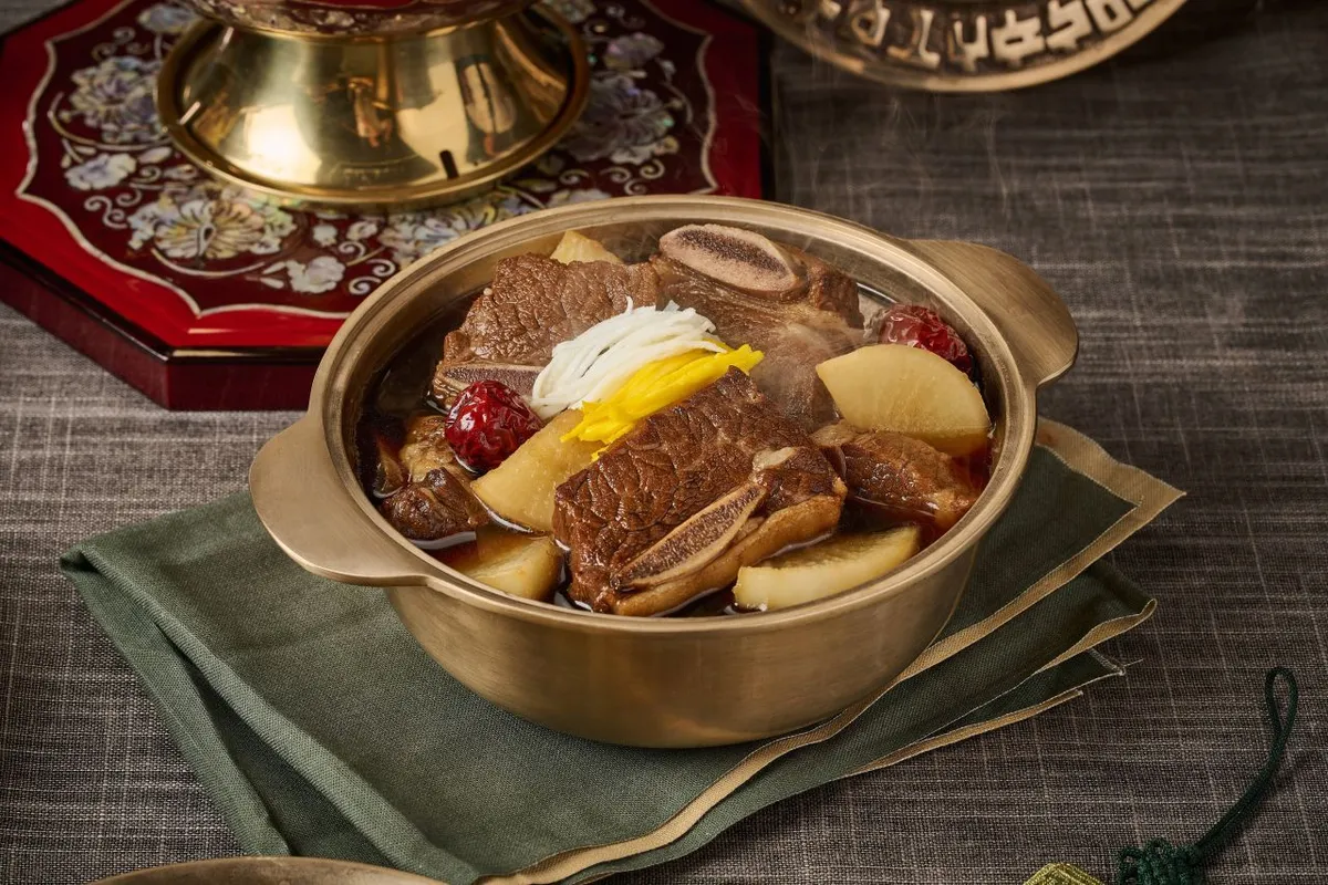 Galbijjim in a brass pot with beef ribs, Korean radish, jujubes, and egg garnish
