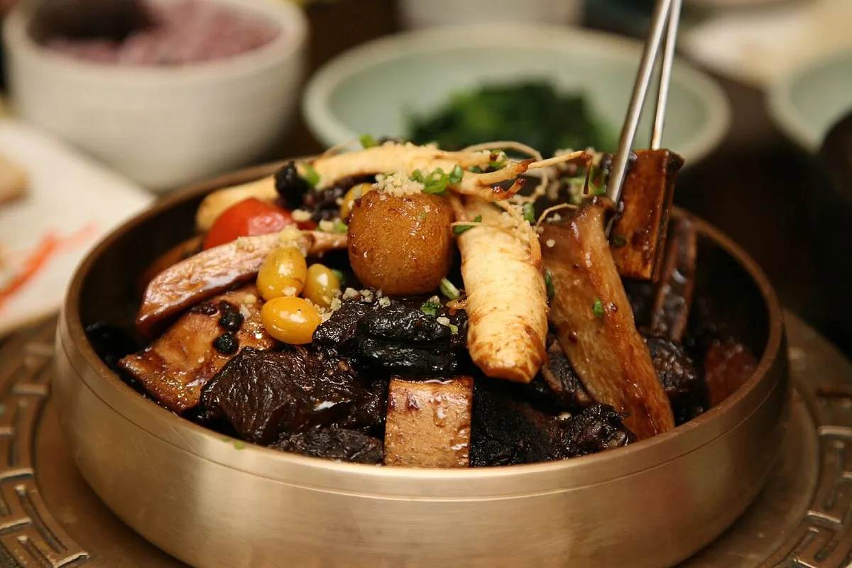 Galbijjim in a brass bowl with beef rib bones, ginkgo nuts, mushrooms, and vegetables