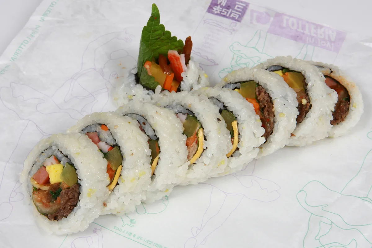 Sliced gimbap rolls with rice egg vegetables and laver for a gimbap guide