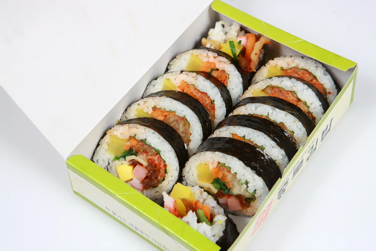 Kimchi gimbap slices with red filling for a Korean seaweed rice rolls guide