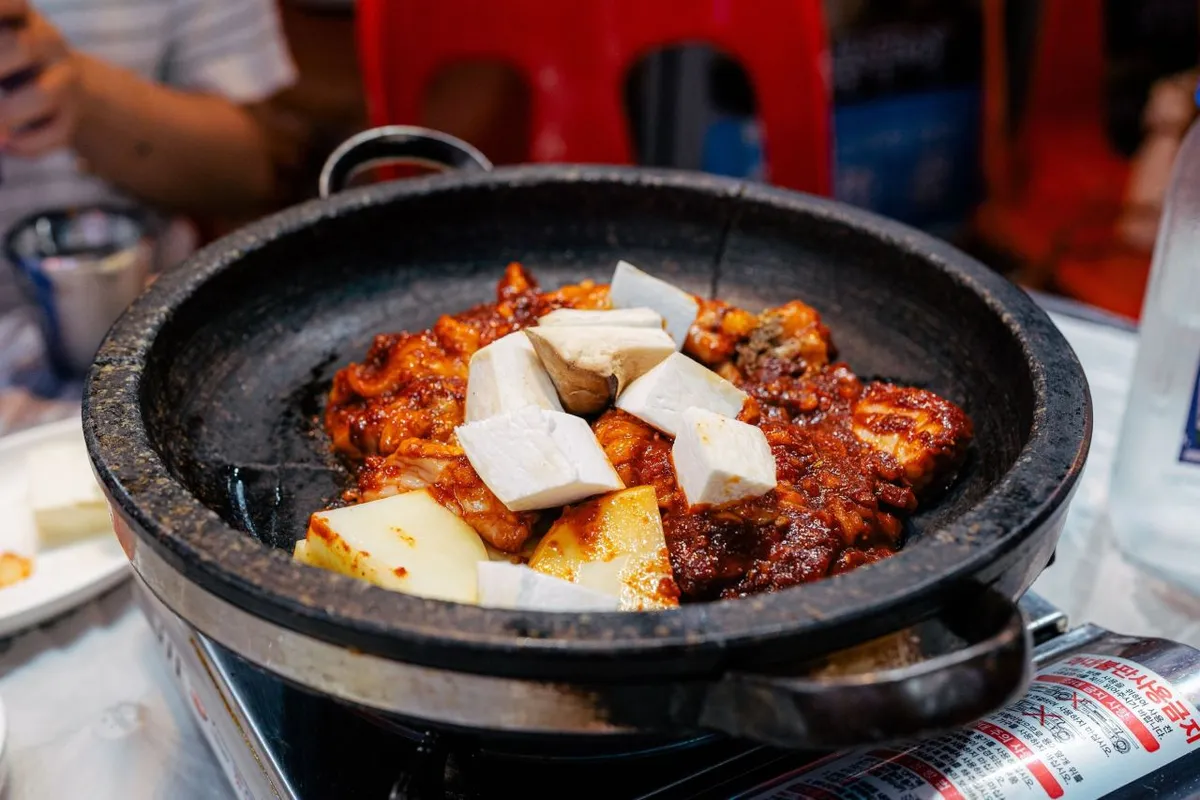 Seasoned gopchang cooking in a round pan at Bupyeong Yang Gopchang in Busan