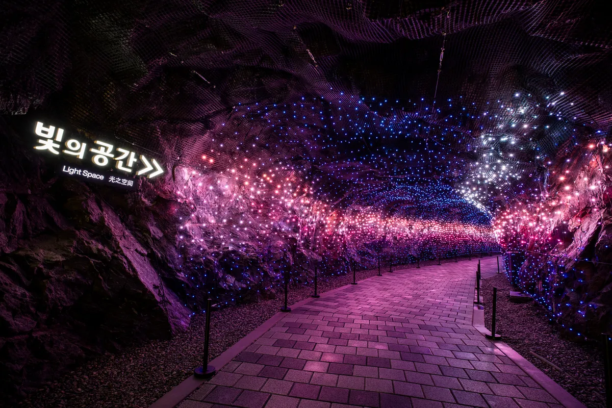 Purple light corridor in the Light Space section of Gwangmyeong Cave