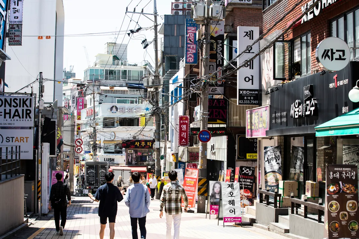 Tree-lined Hongdae shopping street near Hongik University Station for Hongdae Shopping Guide 2026
