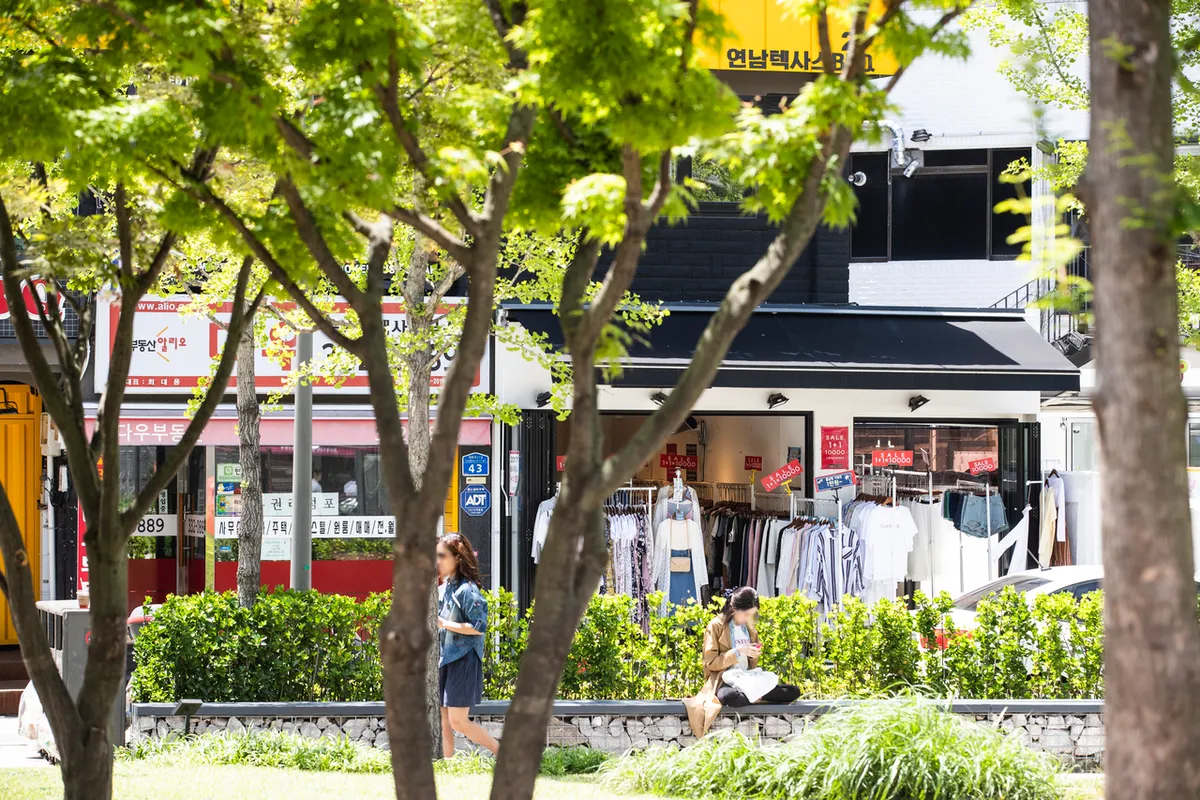 Small storefronts and trees near Yeonnam-dong for Hongdae shopping extension