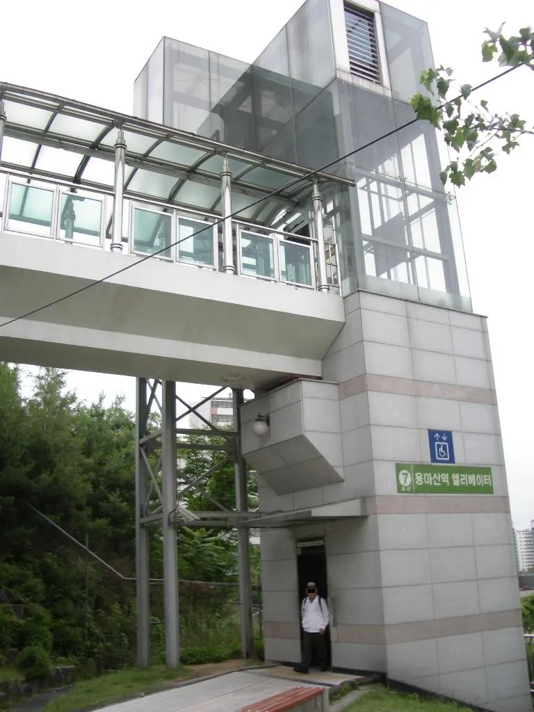 Street-level elevator tower beside Yongmasan subway station in Seoul.
