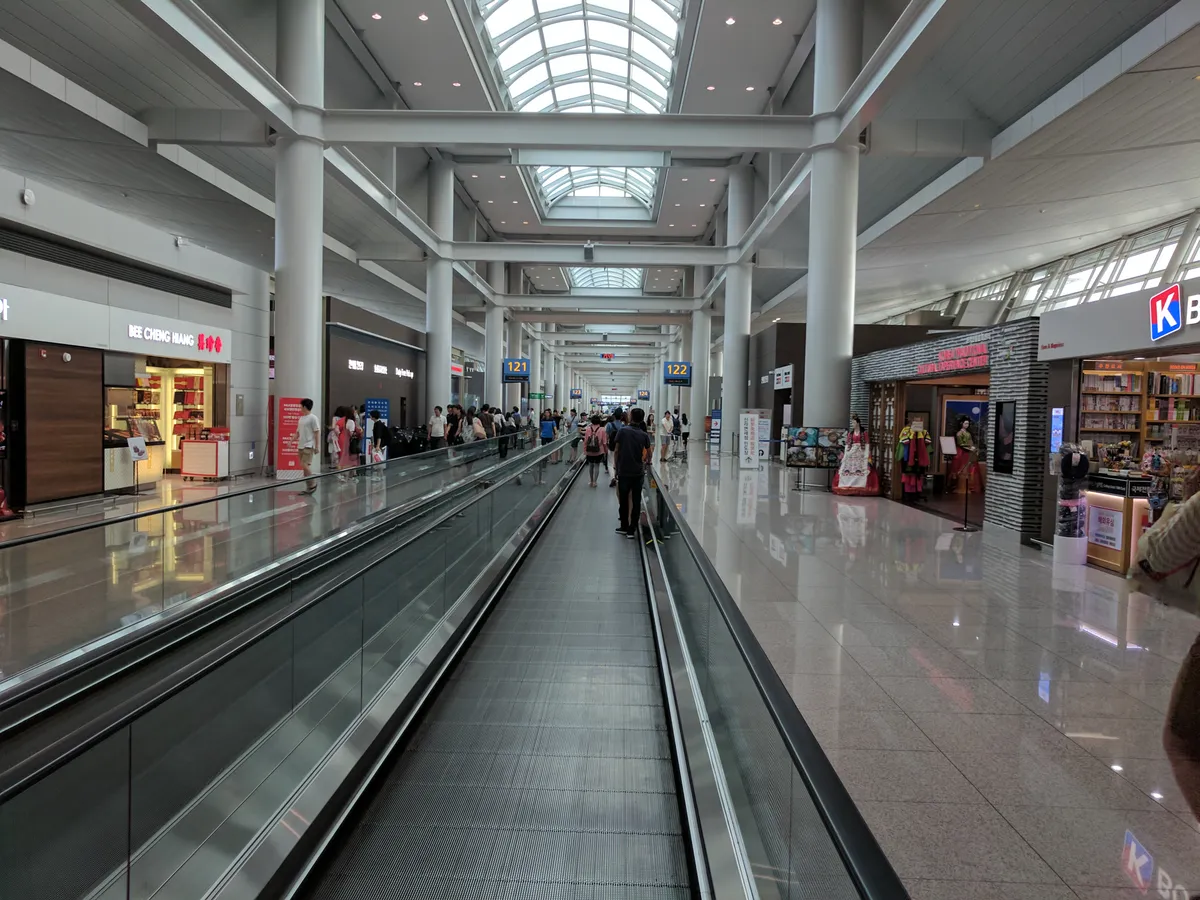 Moving walkway through a shop-lined concourse at Incheon Airport