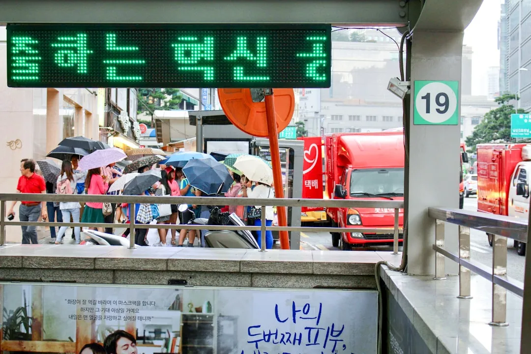 People waiting near a Seoul bus stop for KakaoMap and Naver Map live bus tracking