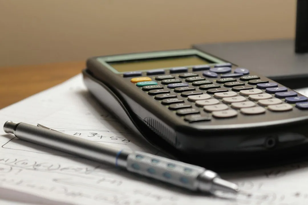 Calculator and pen on handwritten papers for a KORAIL Pass fare comparison.