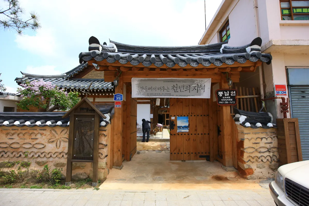 Tiled entrance gate and timber doors at Pungnamheon, an illustrative hanok accommodation photograph