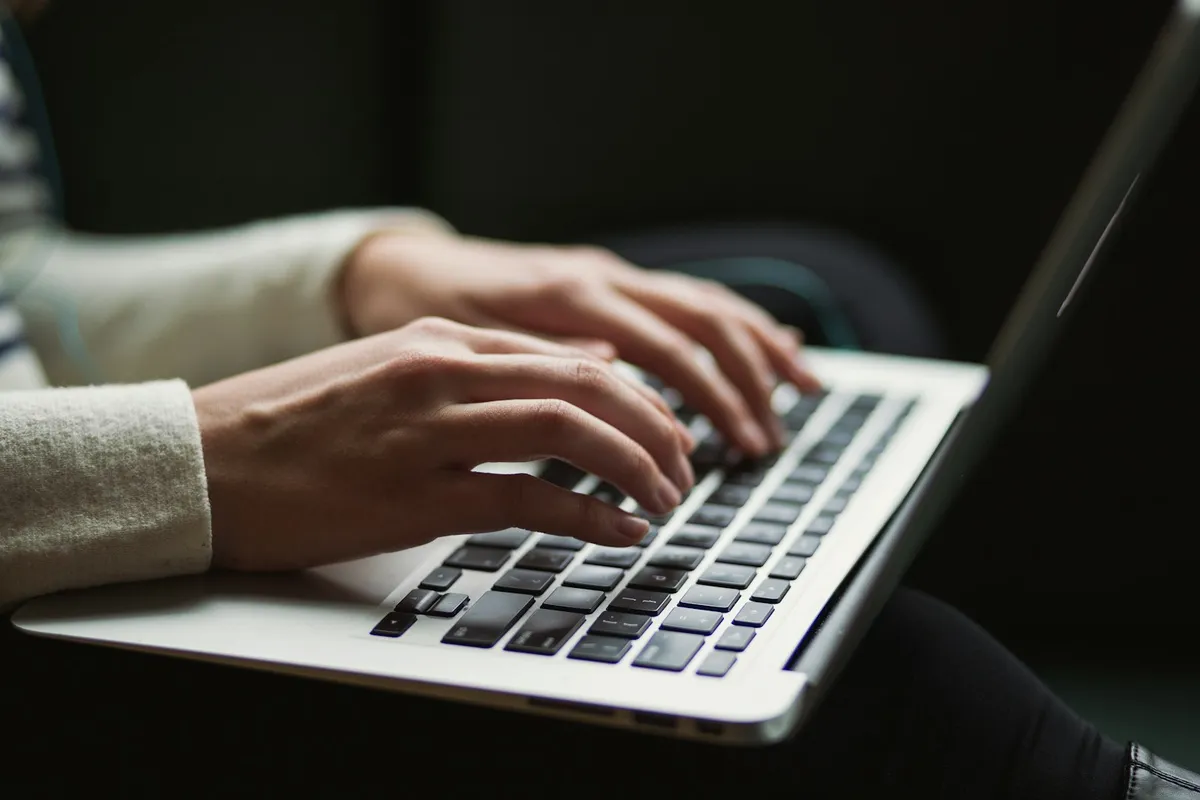 Hands typing on a laptop during online arrival declaration preparation