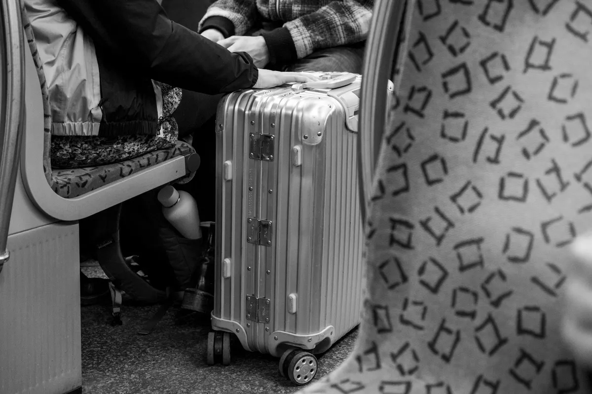Two travelers seated beside suitcases for a shared arrival itinerary