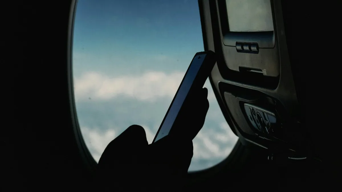 Passenger checking a smartphone during a flight before arrival