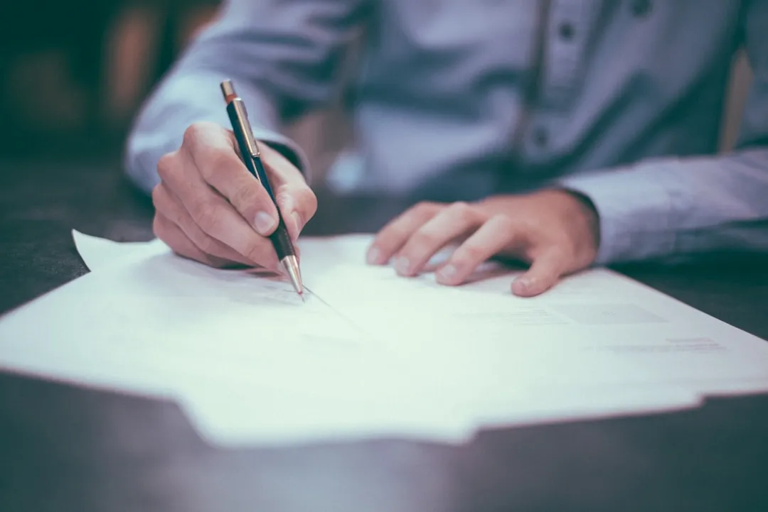 Applicant completing paper documents for a Korean visitor visa