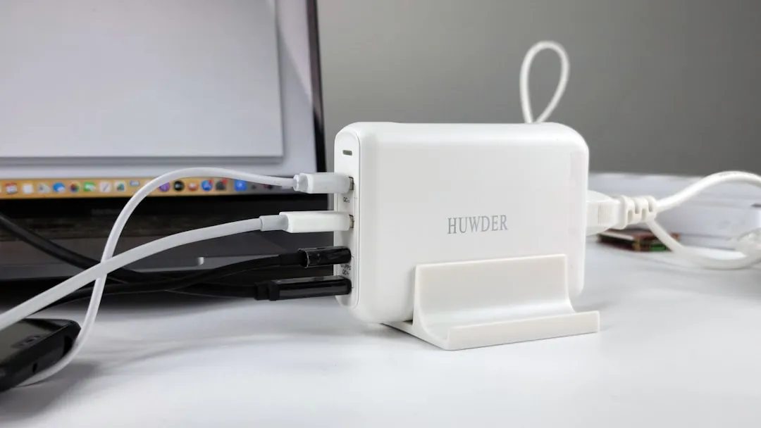 Multiport charger connected to laptop and cables for Korea travel adapter planning