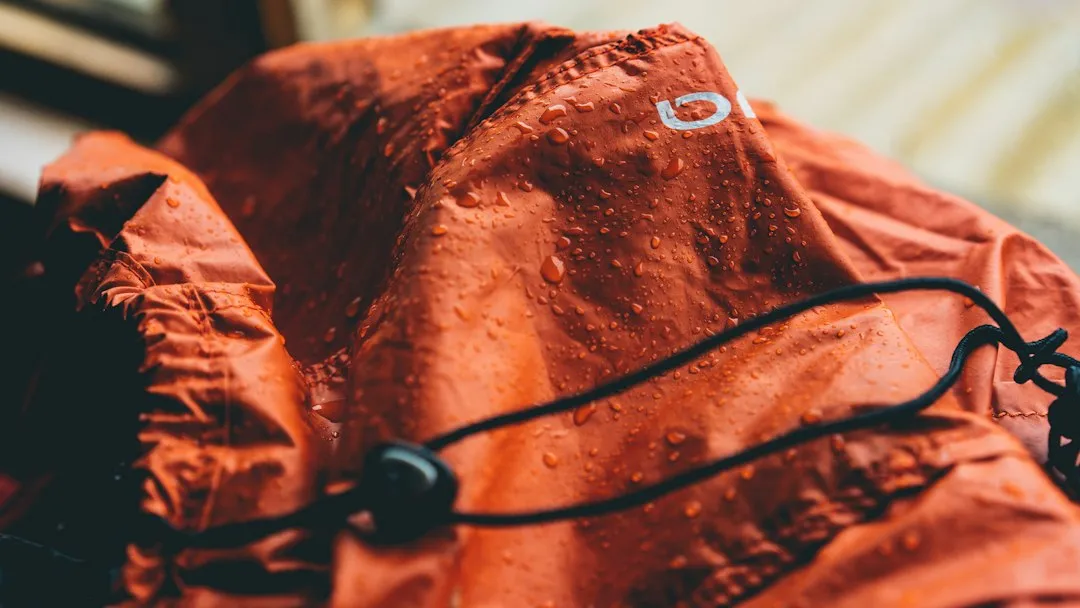 Water droplets on a red waterproof jacket for Korea rainy season packing