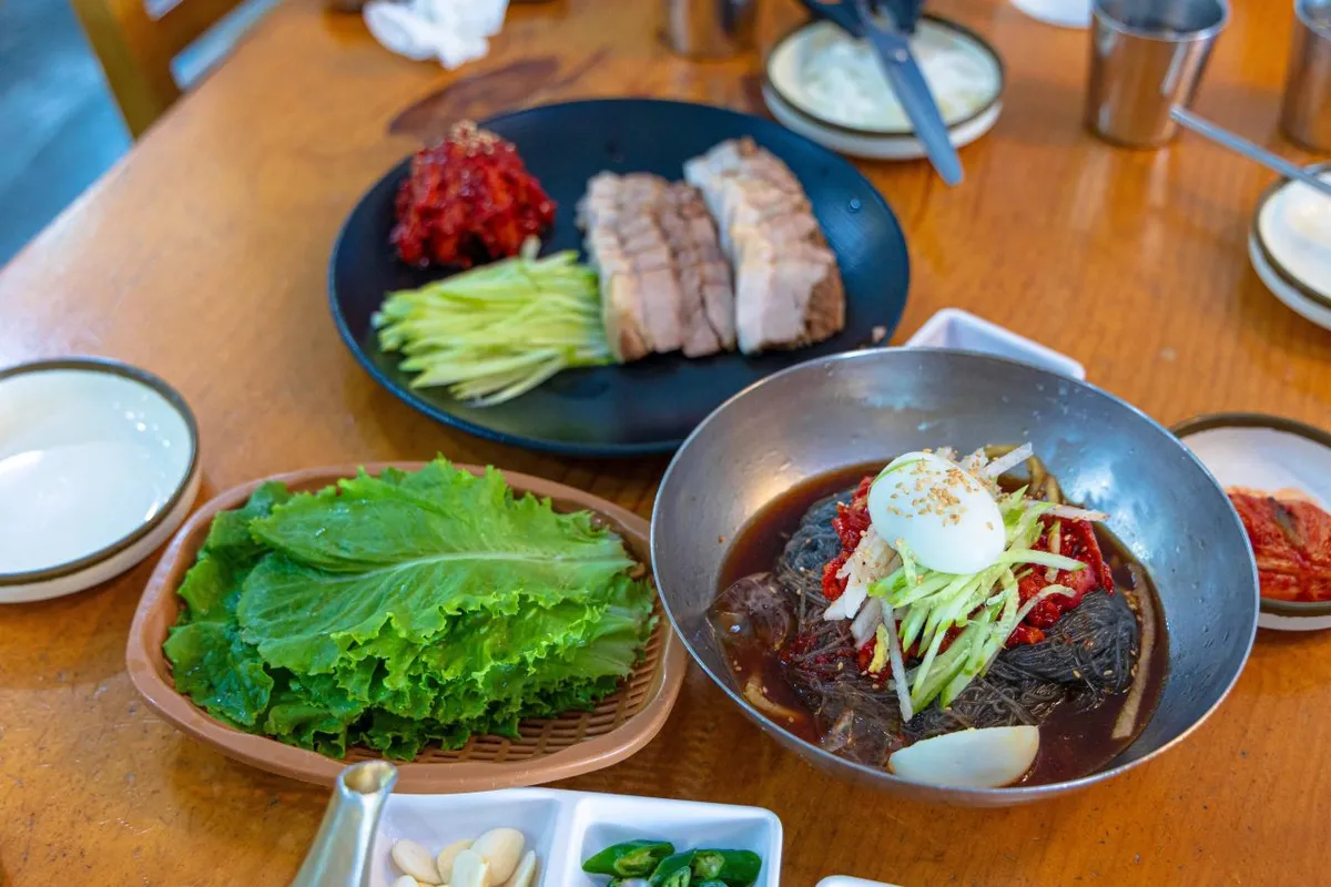 Bibim naengmyeon with sliced meat and cucumber for a cold noodle guide