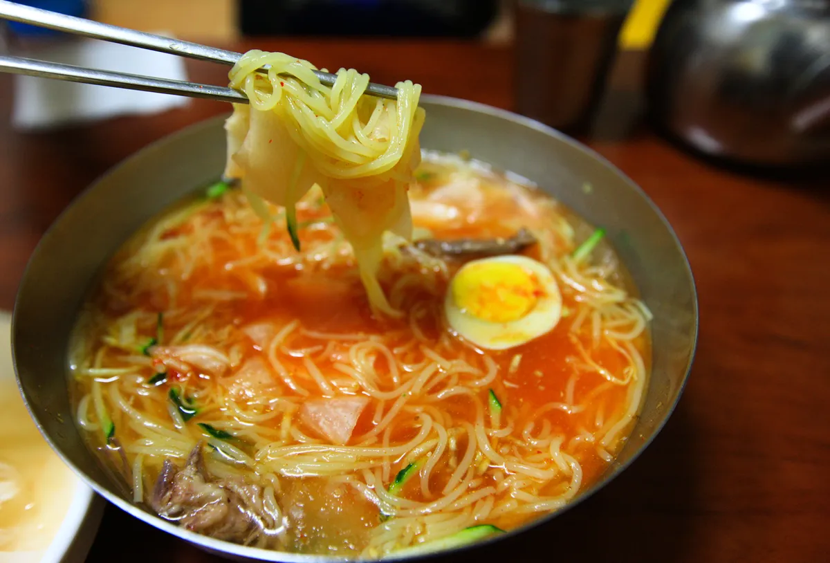 Busan milmyeon in chilled broth with egg and cucumber for a Korean cold noodles guide