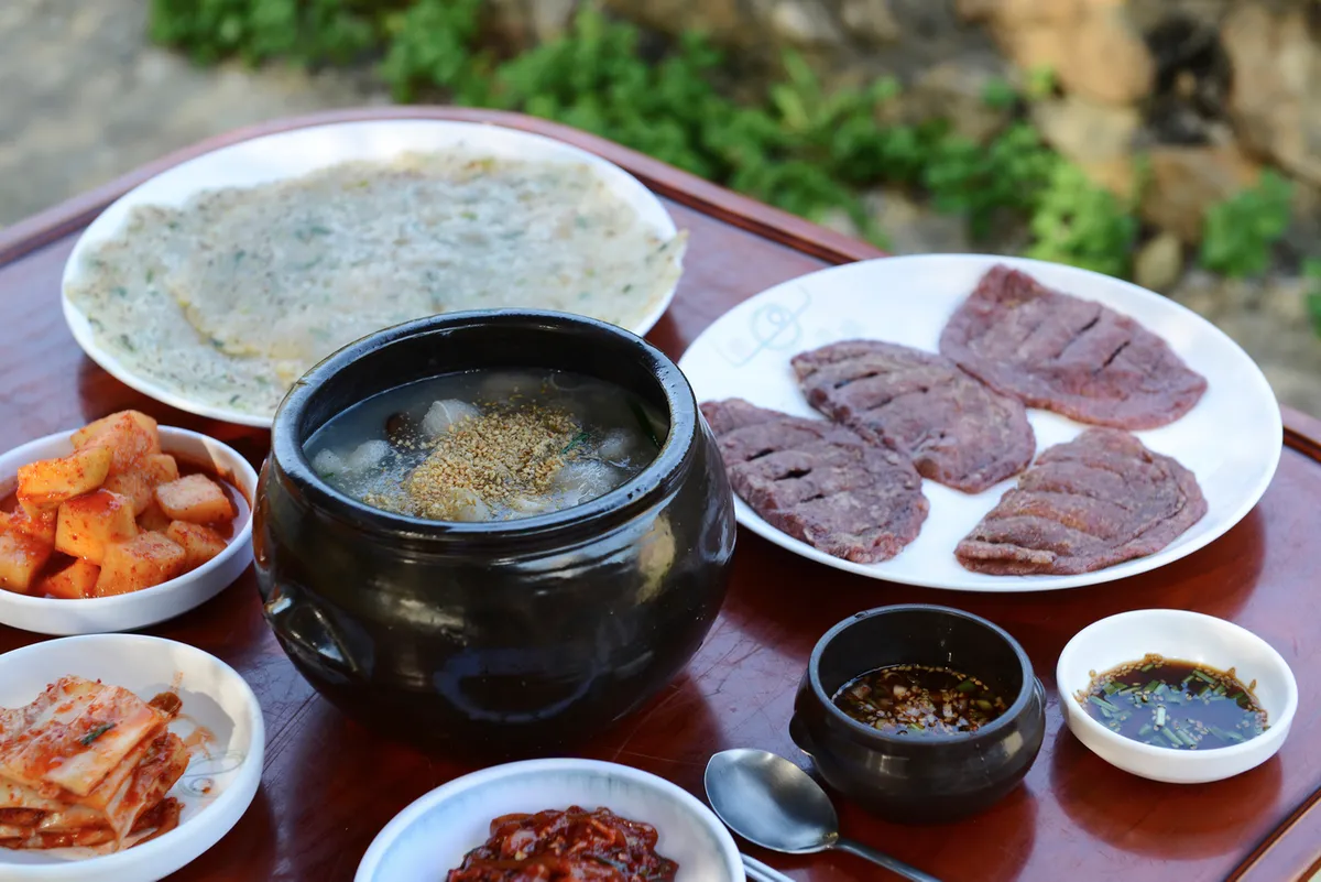 Potato pancake and regional Korean dishes on a table for Korean Jeon Guide
