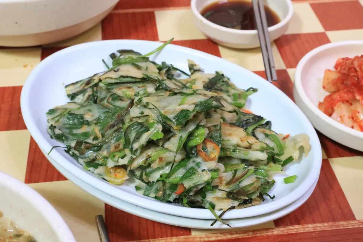 Buchu-jeon chive pancake served on a long plate for Korean Jeon Guide