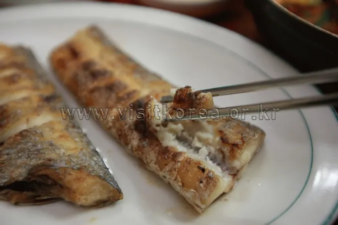 Grilled hairtail fish served with Korean seafood side dishes
