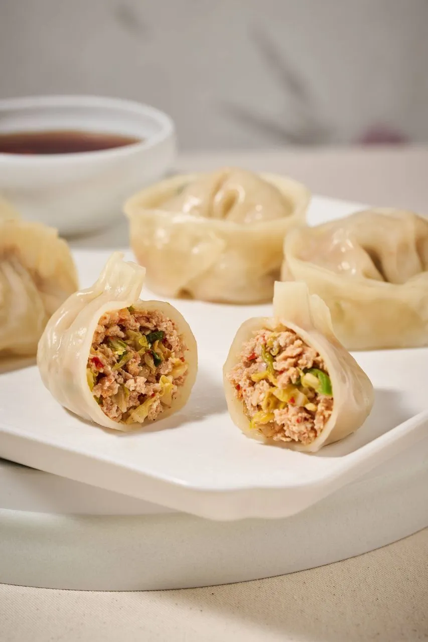 Kimchi dumplings arranged on a plate for a Korean mandu guide