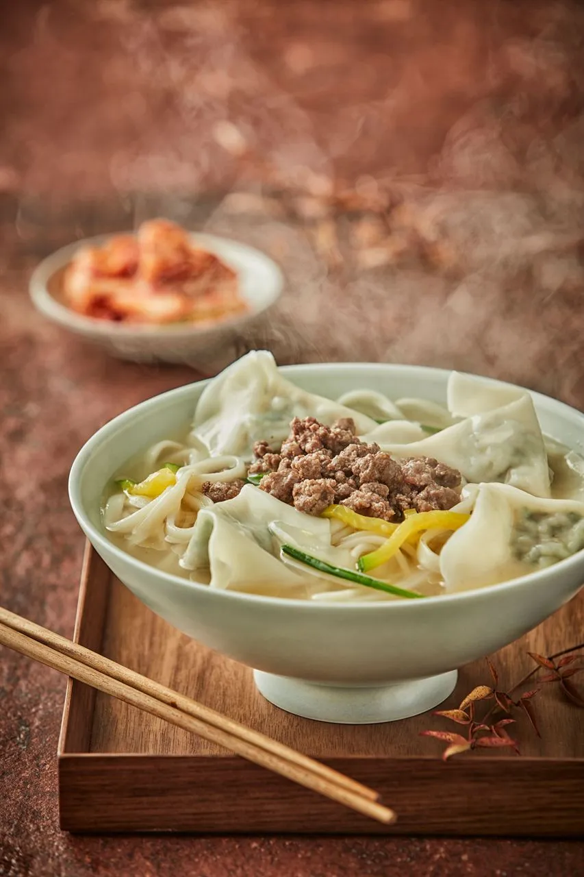 Bowl of manduguk dumpling soup with broth for a Korean mandu guide
