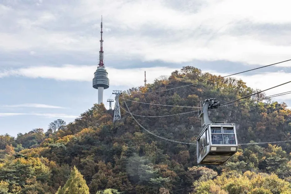 Namsan Cable Car approaching N Seoul Tower above the forested slope
