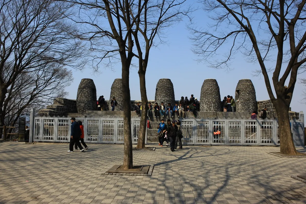 Stone beacon mounds and visitors at the Namsan summit plaza
