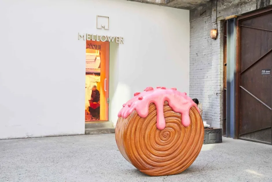 Oversized pastry sculpture with pink icing outside Mellower café in a Seongsu-dong Cafe Street reference photograph