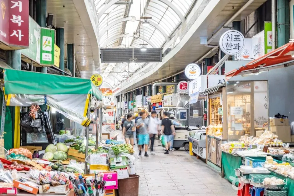 Fresh vegetables and seafood counters along the Sinpo International Market arcade