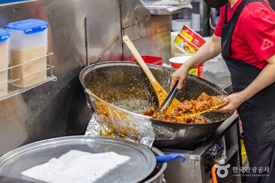 Vendor preparing dakgangjeong at Sinpo International Market in Incheon