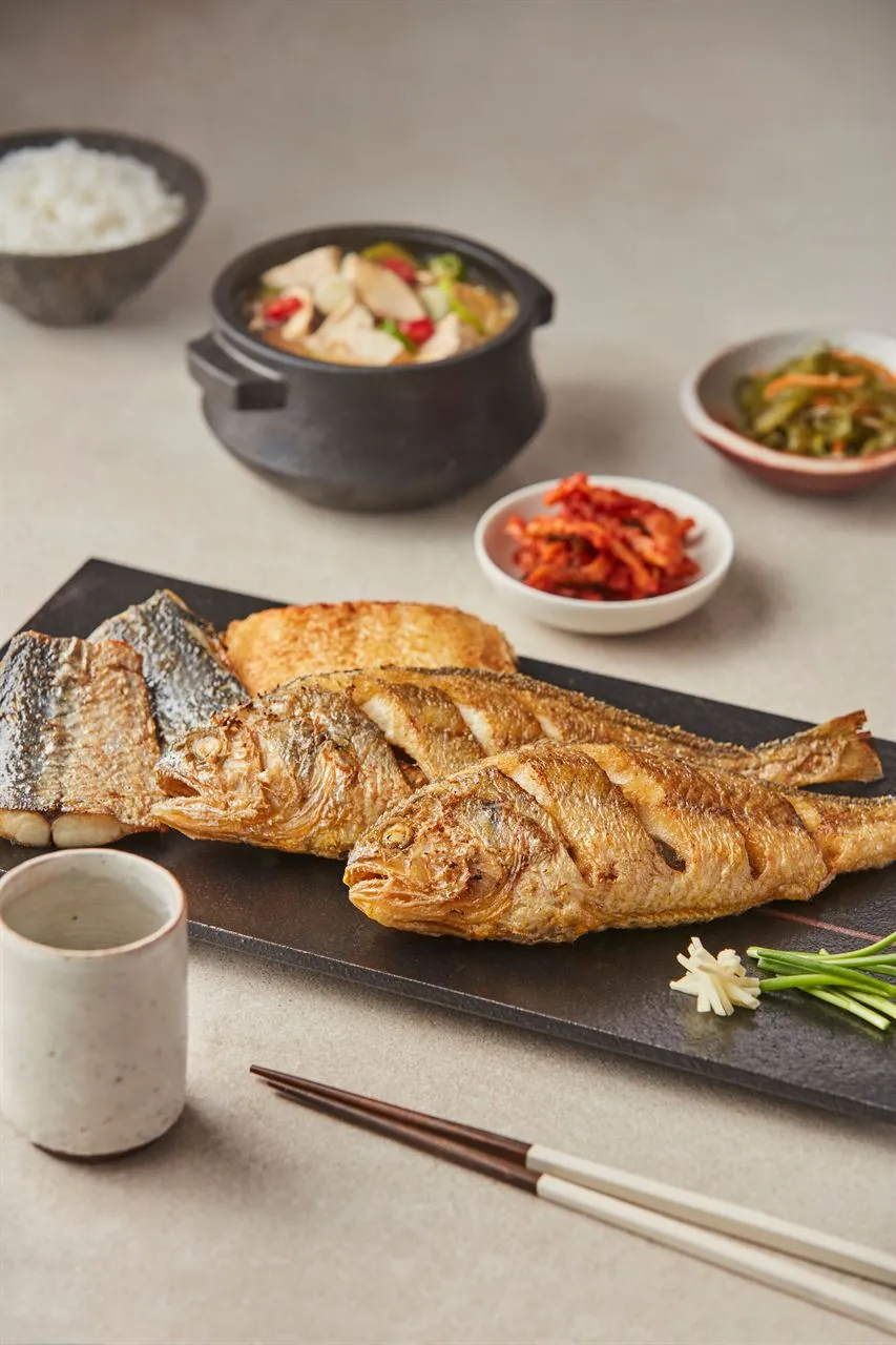 Whole cooked fish with rice and side dishes illustrating meal spending in a Korea travel budget