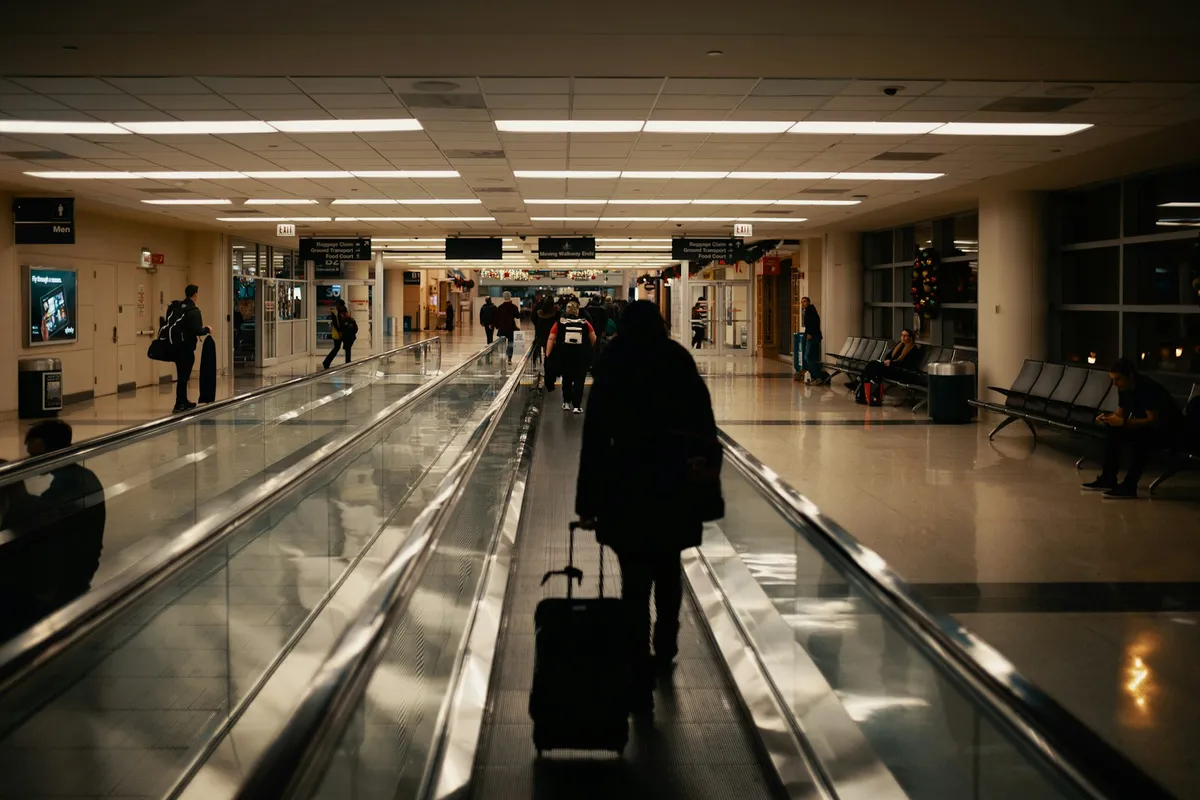 Traveler pulling a suitcase through an airport terminal before a trip to South Korea