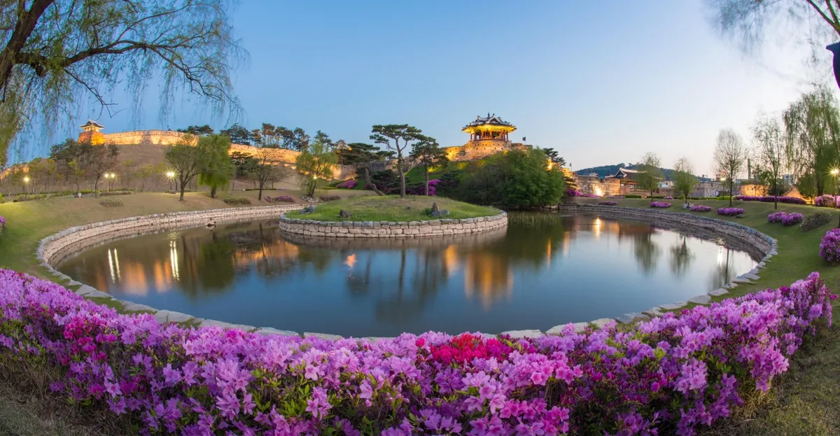 Yongyeon Pond at night below Banghwasuryujeong Pavilion and fortress walls