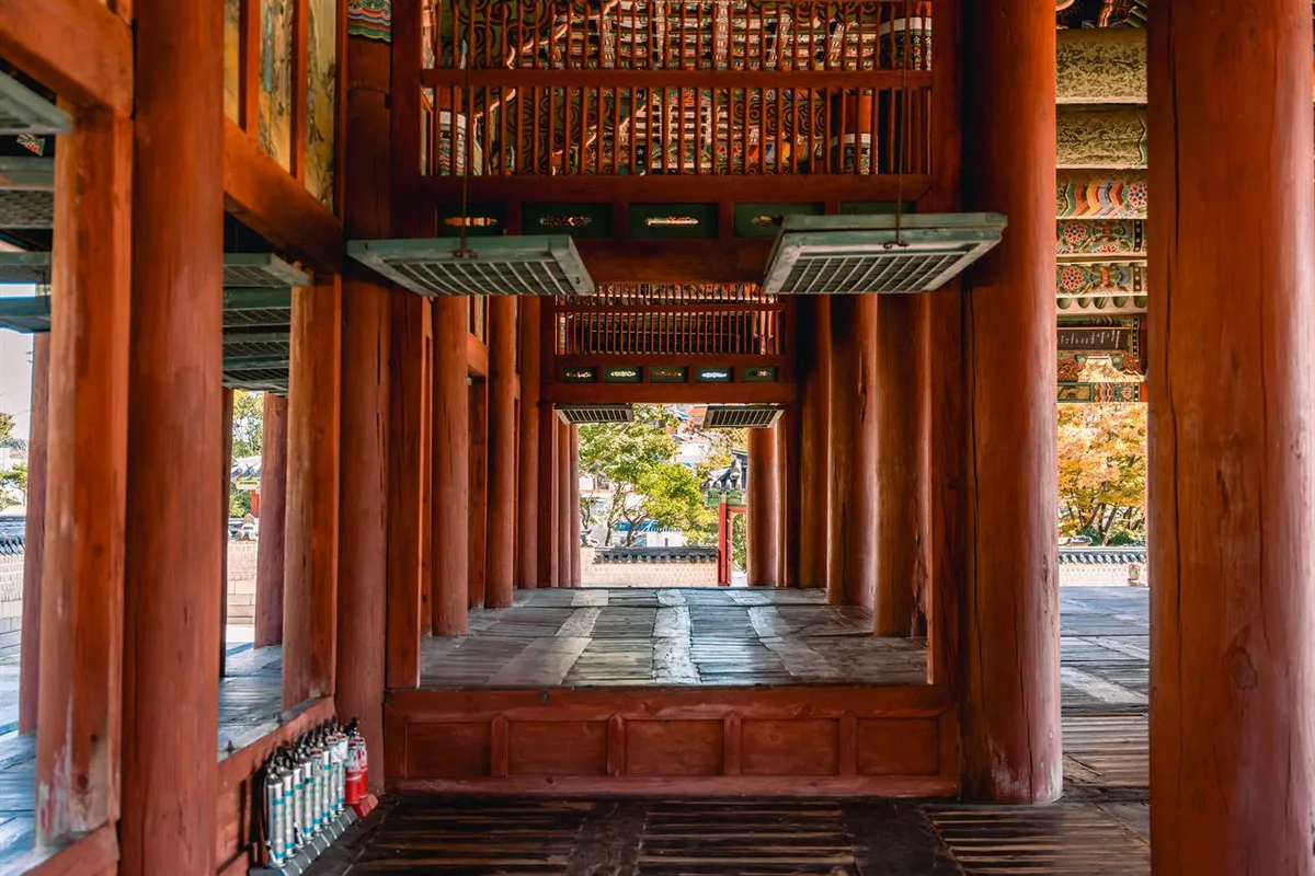 Wooden columns and painted roof structure inside Sebyeonggwan Hall in Tongyeong
