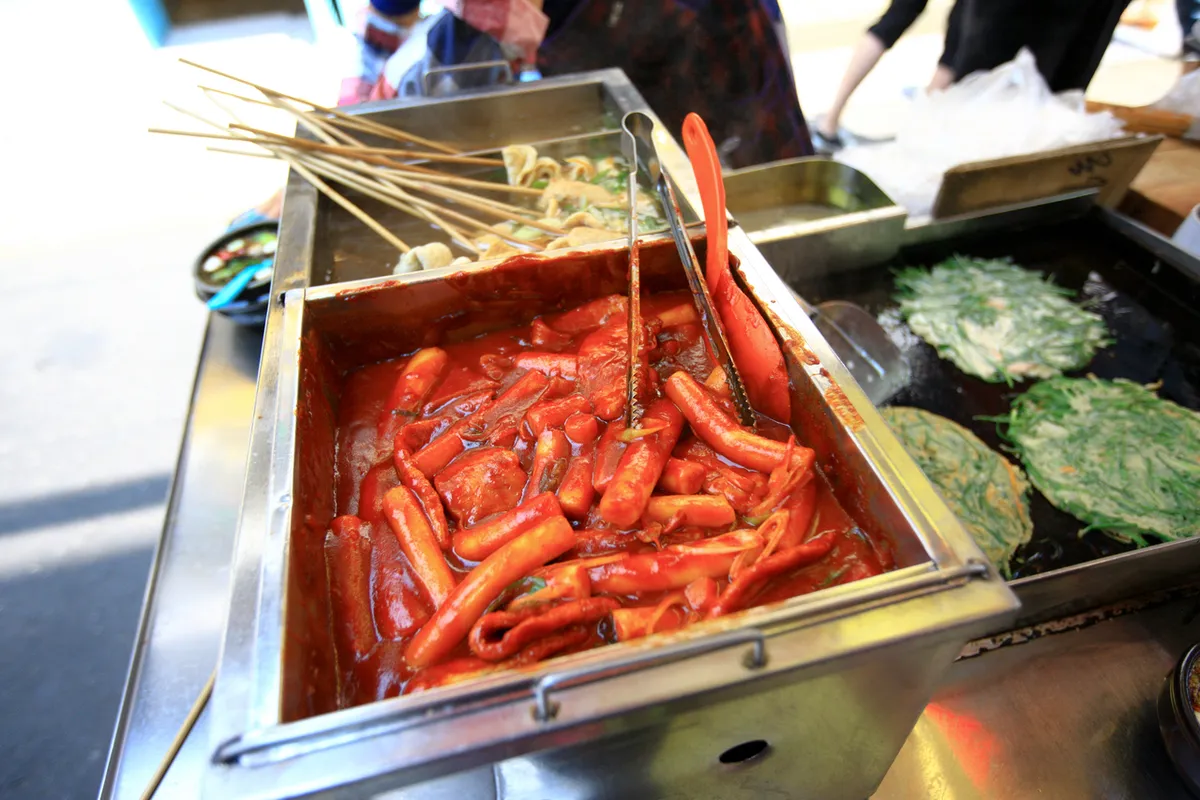 Red tteokbokki rice cakes in a Korean street-food tray in Busan