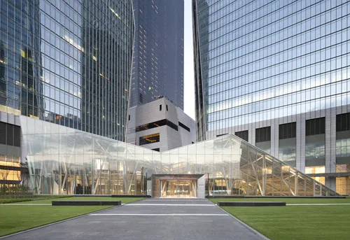Glass entrance pavilion at IFC Mall in Yeouido with lawns and surrounding office towers