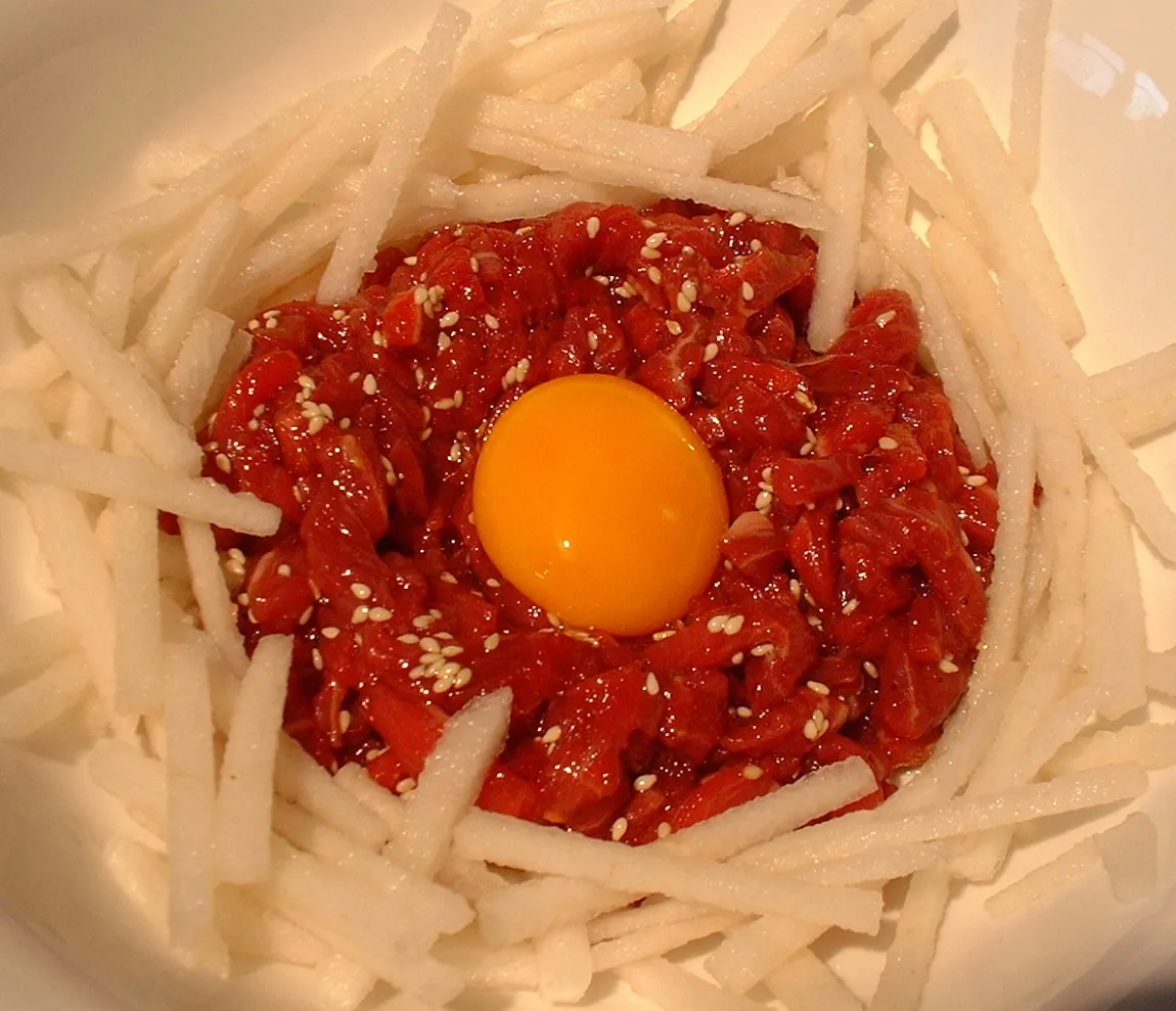 Seasoned yukhoe surrounded by thin strips of Korean pear